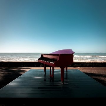 Photo de <a href="https://unsplash.com/fr/@kolodkinmv?utm_source=unsplash&utm_medium=referral&utm_content=creditCopyText">Misha Kolodkin</a>sur <a href="https://unsplash.com/fr/photos/un-piano-rouge-pose-sur-une-plate-forme-en-bois-NyfHyWF3WMo?utm_source=unsplash&utm_medium=referral&utm_content=creditCopyText">Unsplash</a>